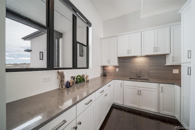 8765 Canyon Wind St, Parker, CO 80138 - kitchen featuring white cabinetry, dark stone countertops, decorative backsplash, and dark wood-style flooring