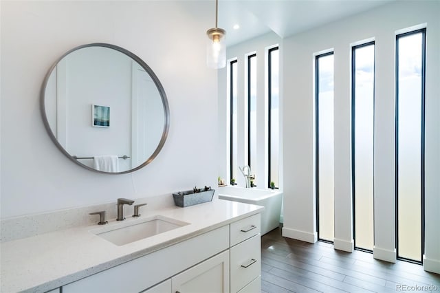 8765 Canyon Wind St, Parker, CO 80138 - full bath featuring vanity, a soaking tub, wood finished floors, and recessed lighting
