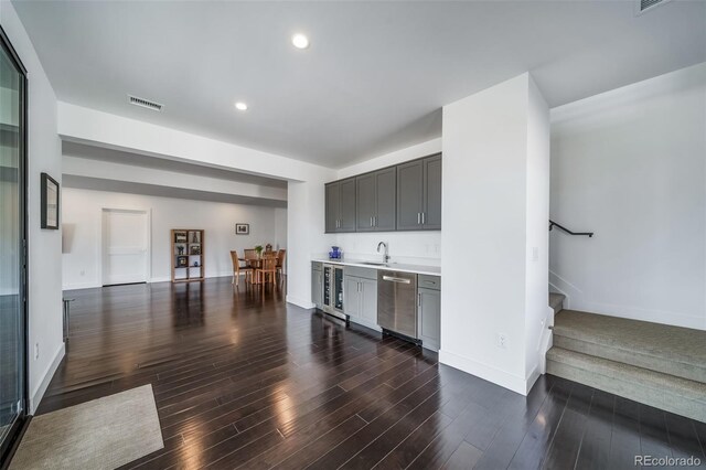 8765 Canyon Wind St, Parker, CO 80138 - indoor wet bar featuring stainless steel dishwasher, stairs, dark wood-style flooring, recessed lighting, and wine cooler