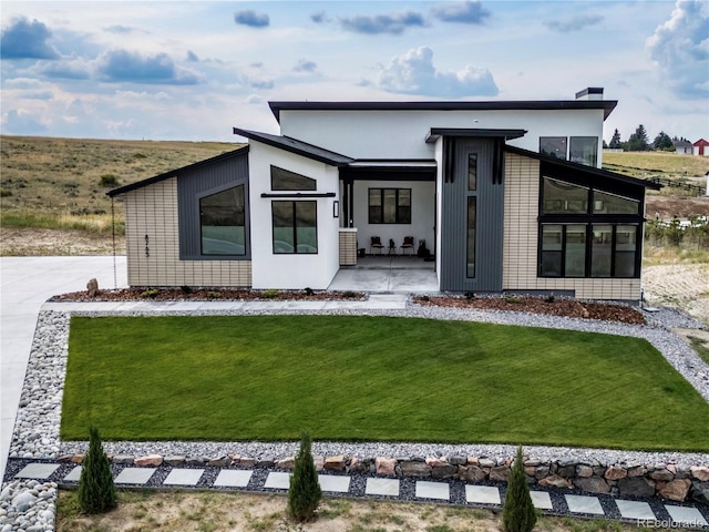 8765 Canyon Wind St, Parker, CO 80138 - back of property featuring a lawn, a patio area, and a sunroom
