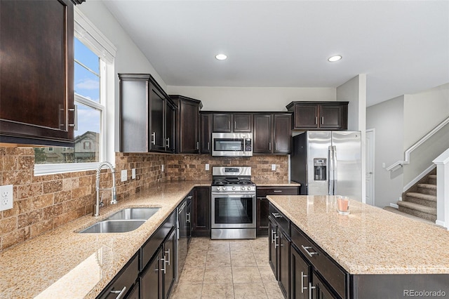 kitchen featuring light stone countertops, sink, appliances with stainless steel finishes, and tasteful backsplash