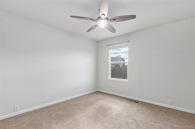 carpeted spare room featuring ceiling fan