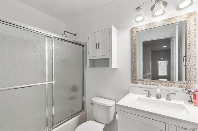 full bathroom featuring bath / shower combo with glass door, vanity, and toilet