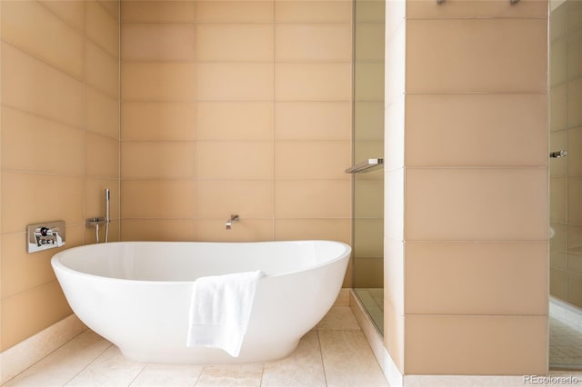 1133 14th St Unit 2000, Denver, CO 80202 - full bathroom featuring tile walls, a soaking tub, and tile patterned flooring