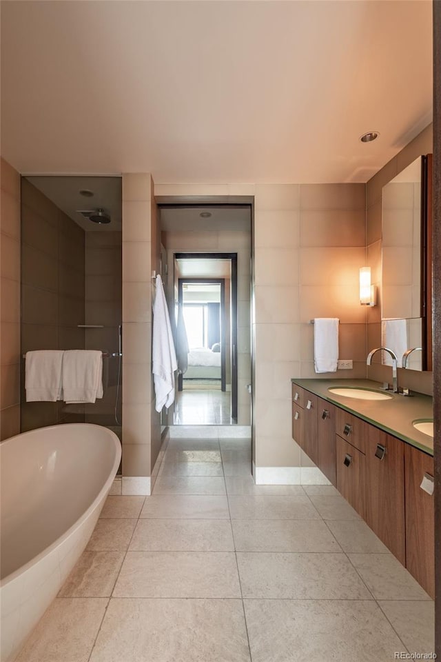 1133 14th St Unit 2000, Denver, CO 80202 - ensuite bathroom featuring double vanity, a freestanding tub, tile patterned floors, tile walls, and a shower