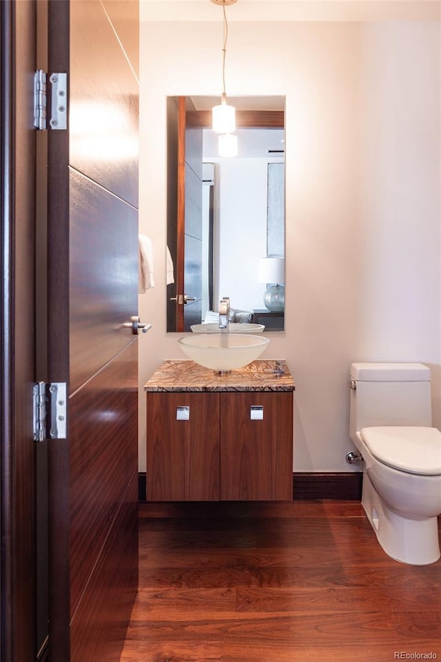 1133 14th St Unit 2000, Denver, CO 80202 - half bathroom featuring vanity, wood finished floors, toilet, and baseboards