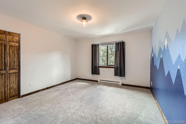 spare room featuring a baseboard radiator, carpet floors, and baseboards