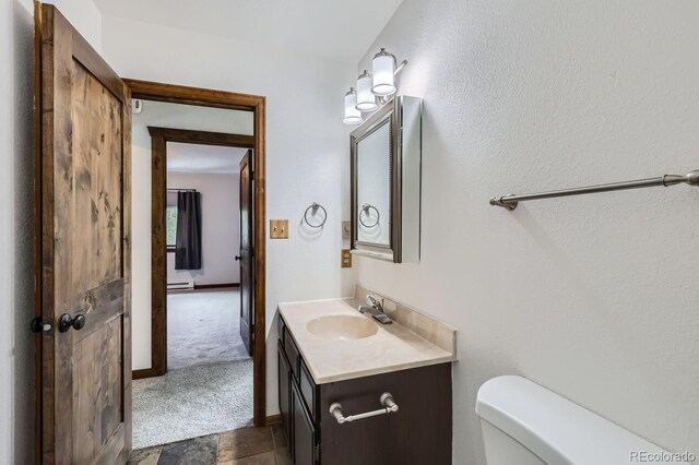 bathroom featuring vanity, toilet, and baseboards