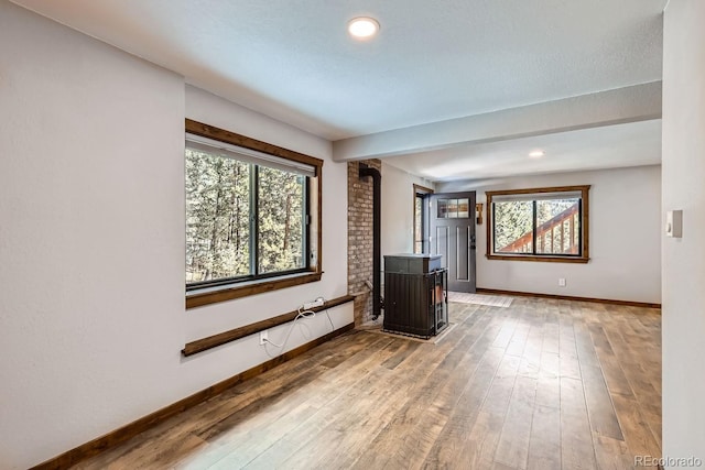 unfurnished room featuring baseboards, plenty of natural light, and light wood-style flooring