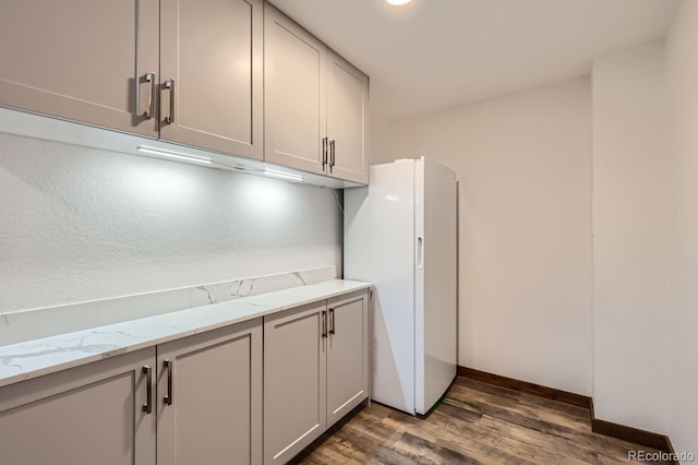 laundry room featuring dark wood finished floors and baseboards