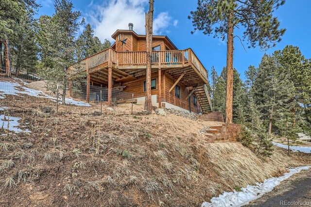 back of property featuring stairway and a wooden deck