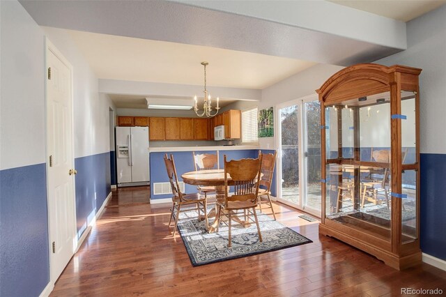 dining area featuring dark hardwood / wood-style flooring and a notable chandelier