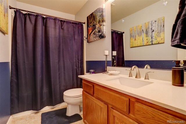 bathroom with tile patterned flooring, vanity, and toilet