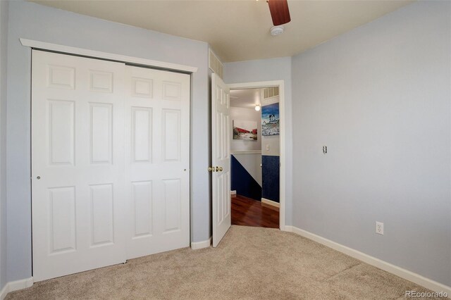 unfurnished bedroom with carpet, a closet, and ceiling fan