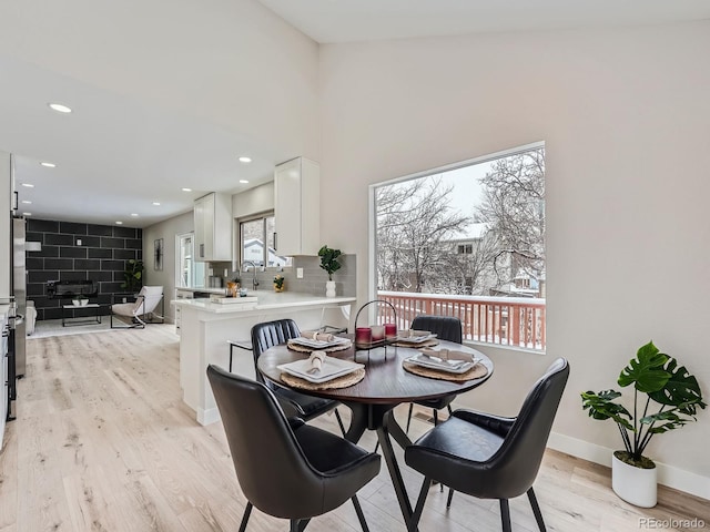 dining room with sink and light wood-type flooring