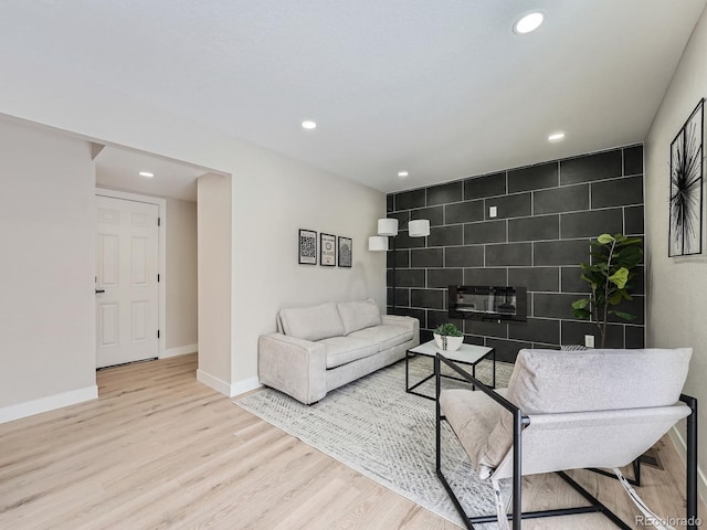 living room with light hardwood / wood-style flooring and tile walls