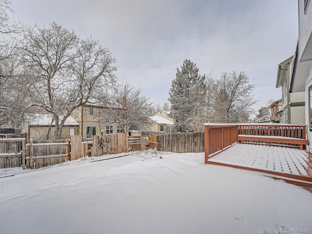 yard layered in snow featuring a deck