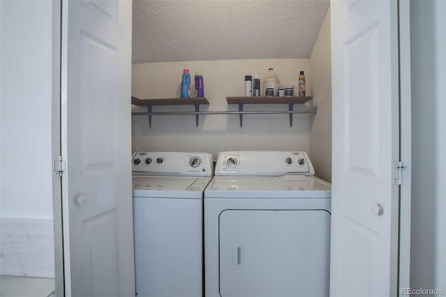 clothes washing area featuring a textured ceiling and washing machine and clothes dryer