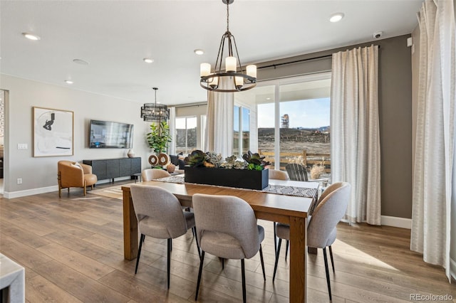 dining room with an inviting chandelier, recessed lighting, baseboards, and wood finished floors