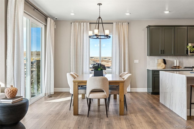 dining space featuring an inviting chandelier, a wealth of natural light, and baseboards