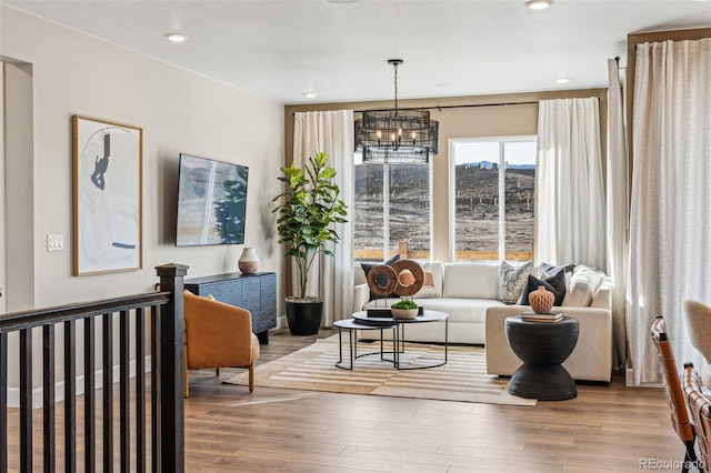 living area with an inviting chandelier, recessed lighting, and wood finished floors