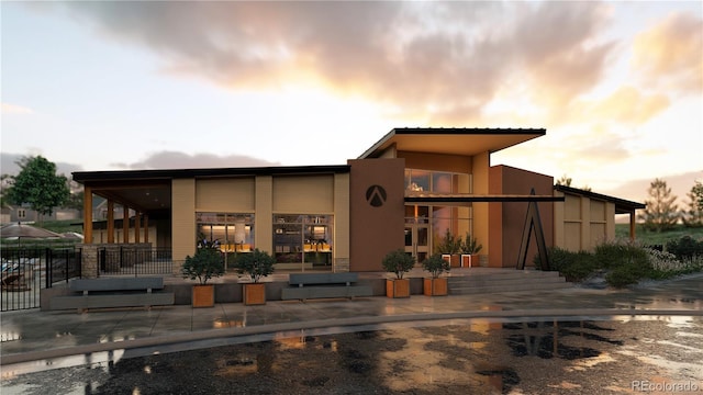 back of property at dusk featuring stucco siding
