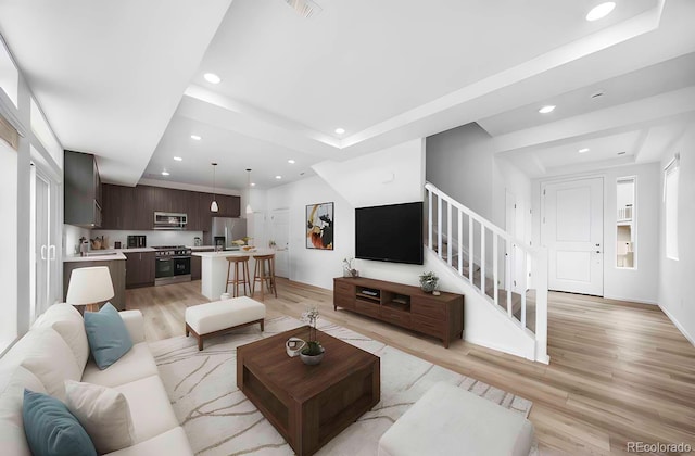 1175 Highview Dr, Erie, CO 80516 - living area featuring a raised ceiling, recessed lighting, stairs, and light wood finished floors