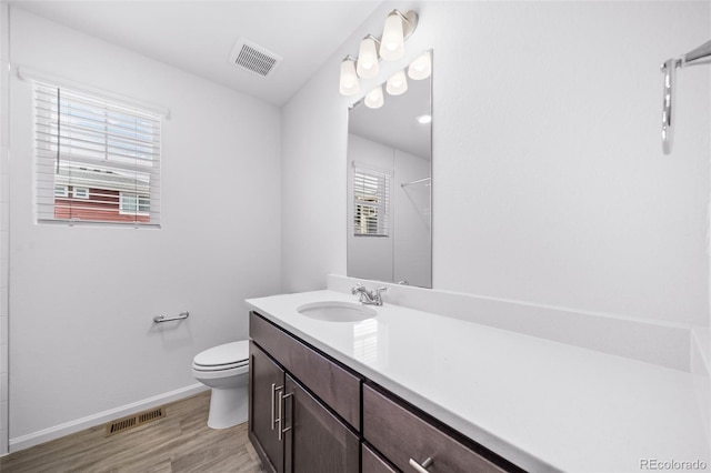 1175 Highview Dr, Erie, CO 80516 - bathroom with toilet, vanity, wood finished floors, baseboards, and a shower