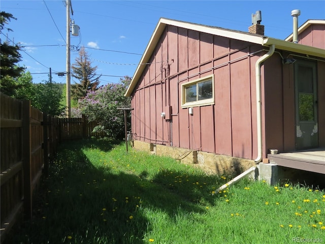 135 E 2nd St, Nederland, CO 80466 - view of home's exterior with board and batten siding, a chimney, and a fenced backyard