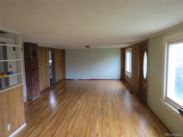 135 E 2nd St, Nederland, CO 80466 - unfurnished living room with light wood finished floors, plenty of natural light, and a textured ceiling
