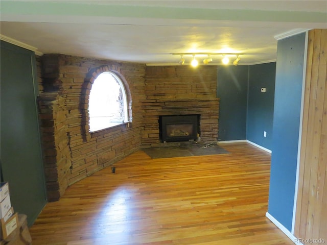 135 E 2nd St, Nederland, CO 80466 - unfurnished living room with wood finished floors, a stone fireplace, and ornamental molding