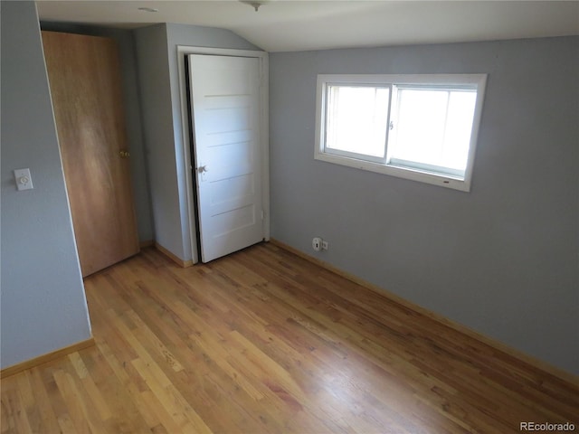 135 E 2nd St, Nederland, CO 80466 - unfurnished bedroom with light wood finished floors, vaulted ceiling, and a closet