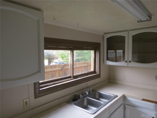 135 E 2nd St, Nederland, CO 80466 - kitchen with white cabinets, ornamental molding, light countertops, and glass insert cabinets