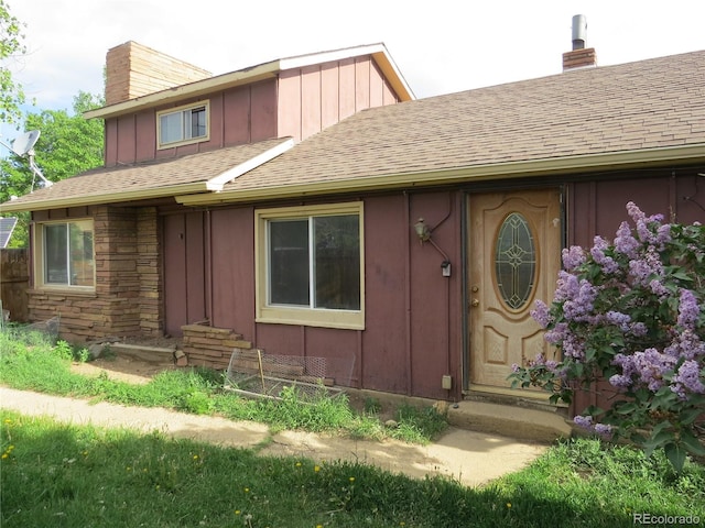 135 E 2nd St, Nederland, CO 80466 - property entrance with a chimney, board and batten siding, and a shingled roof