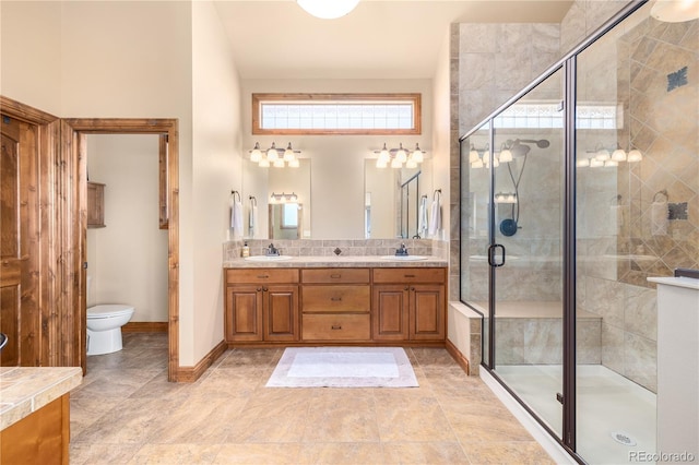 bathroom with vanity, toilet, and a shower with shower door