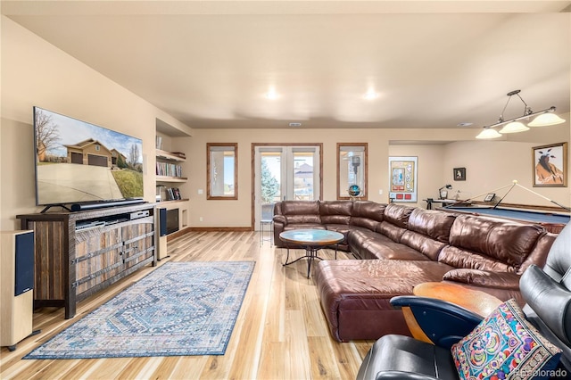 living room with light hardwood / wood-style flooring and built in features