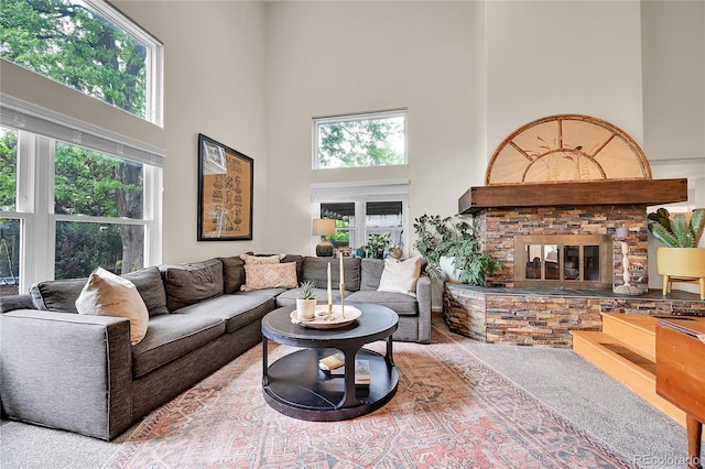 living room with a towering ceiling and a fireplace