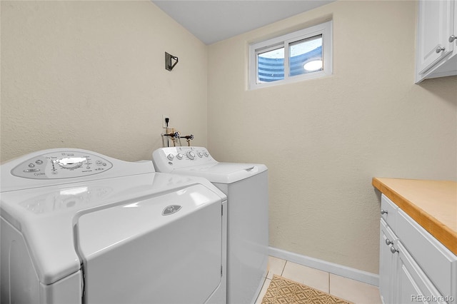 laundry area with cabinet space, washer and clothes dryer, light tile patterned floors, and baseboards