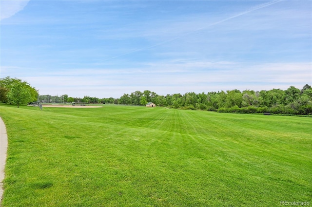 surrounding community with a lawn, golf course view, and view of wooded area