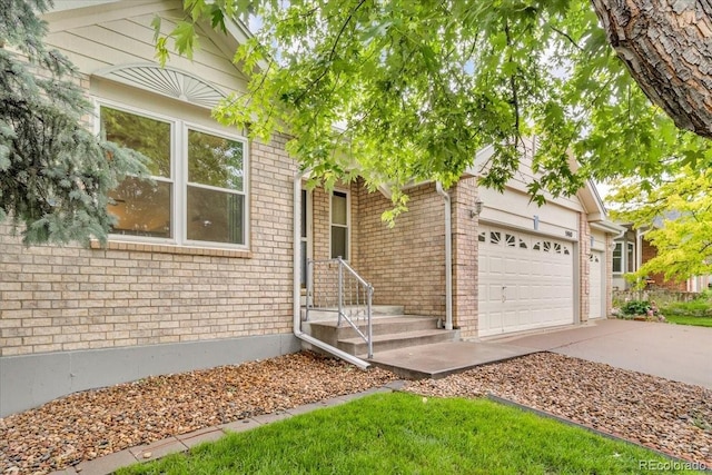 5960 S Estes St, Littleton, CO 80123 - view of front facade featuring driveway, an attached garage, and brick siding