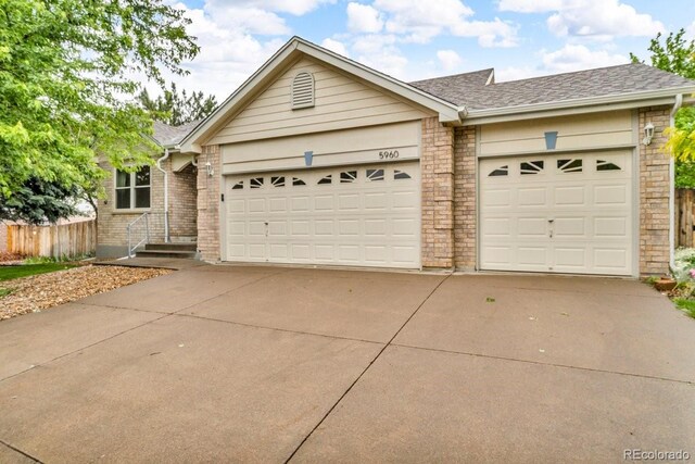 5960 S Estes St, Littleton, CO 80123 - ranch-style home with concrete driveway, an attached garage, a shingled roof, and brick siding
