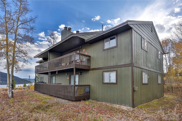 back of property with a deck with mountain view and a balcony