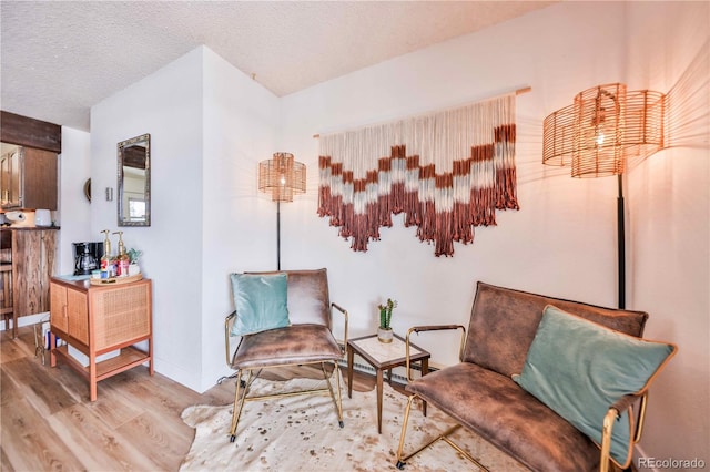 living area with a textured ceiling and light wood-type flooring