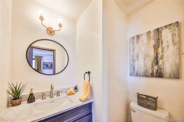 bathroom featuring vanity, lofted ceiling, and toilet