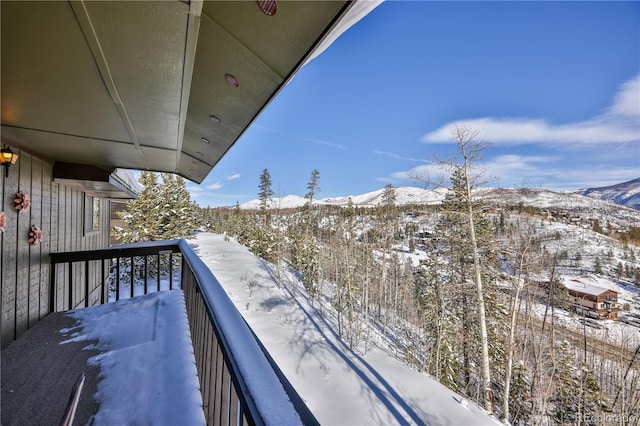 snow covered back of property with a mountain view