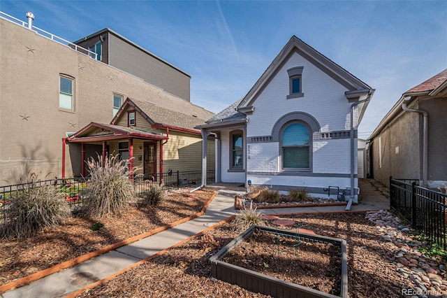 view of front of property featuring brick siding and fence