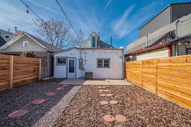 rear view of house with central AC, a patio, and a fenced backyard