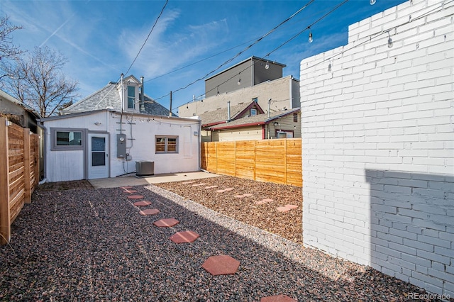 view of yard with a fenced backyard and central AC