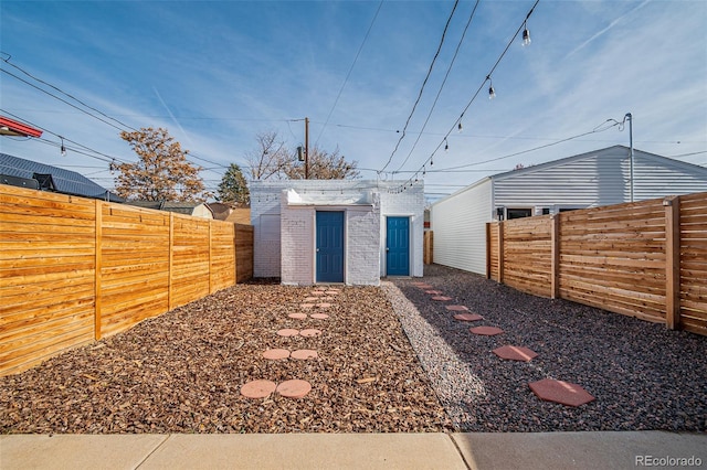 view of yard featuring an outbuilding, a fenced backyard, and a storage shed