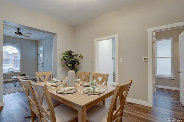 dining area with ceiling fan, baseboards, and wood finished floors